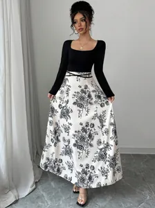 Elegant long-sleeved maxi dress with square neck and floral print skirt detail.