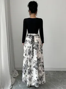 Back view of elegant long sleeve dress with floral print skirt and waist tie.