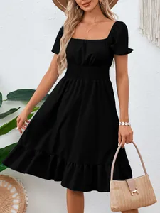 Vista dettagliata di un elegante abito nero a trapezio con vita a punto smock e volant