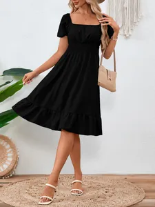 Elegante abito nero a trapezio con vita arricciata e dettagli con bordo a balze