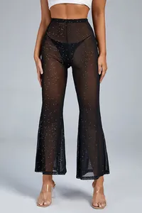 Detail view of sexy high-waisted sheer black mesh flare pants with glitter dot pattern