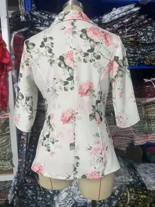 Detail van de achterkant van een modieus damesjack met bloemenprint en driekwart mouwen