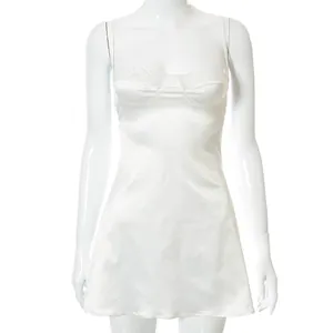 Detailopname van een elegante witte satijnen mini-jurk met een kanten afwerking