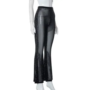 Close-up detail of sexy sheer black mesh flared pants with sparkling glitter accents.