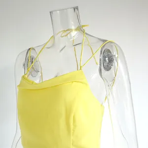 Détail d'une robe courte jaune dos nu à col bénitier sur un mannequin transparent.