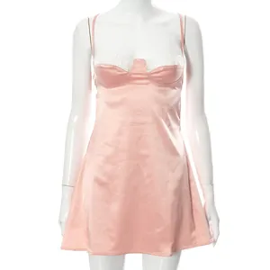 Gedetailleerd overzicht van roze satijnen slipdress met fijn wit kant op de buste.