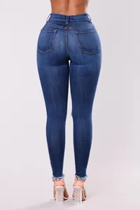 Vista trasera detallada de vaqueros pitillo elásticos azul oscuro con bajos deshilachados