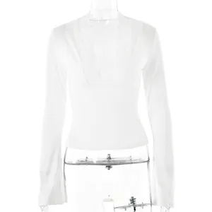 Detail view of the white V-neck top showing delicate floral lace splicing on the neckline