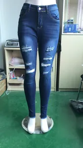 Vista detallada de vaqueros ajustados de mezclilla azules con rotos para mujer en maniquí
