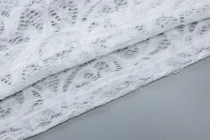 Λεπτομερές κοντινό πλάνο που δείχνει την περίτεχνη λευκή δαντέλα και την υφή πλέγματος.