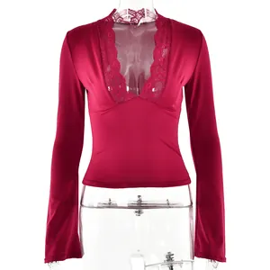 Close-up detail of deep red V-neck top with intricate floral lace patchwork design.