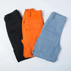Drei lockere Cargo-Hosen in Schwarz, Orange und Blau mit großen funktionalen Seitentaschen