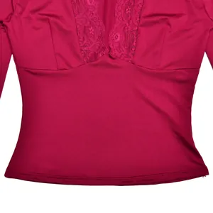 Close-up showing the intricate lace trim and soft fabric detail of the burgundy V-neck top.