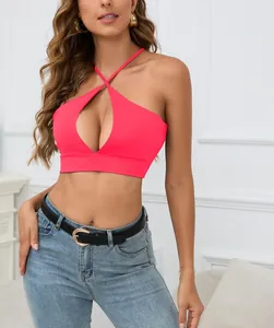 Detalle de top corto rosa neón con cuello halter, abertura frontal y tiras cruzadas.