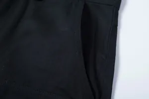 Detailaufnahme des strapazierfähigen schwarzen Stoffes und der Tasche einer Cargo-Hose.