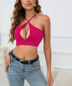 Vista detallada de un top corto tipo halter magenta con abertura frontal y diseño cruzado