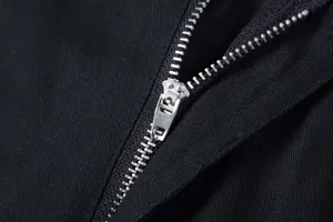 Nahaufnahme eines hochwertigen Metallreißverschlusses an einer schwarzen Cargo-Hose