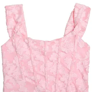 Close-up detail of soft pink floral lace fabric and corset bodice stitching on sleeveless dress