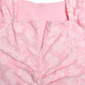 Detailed view of the back invisible zipper and floral textured fabric of pink dress