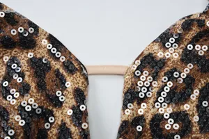 Macro detail of leopard print fabric with shimmering silver sequins and elastic strap.