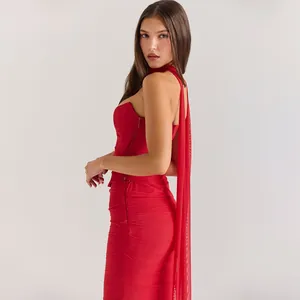 Dettaglio di un elegante completo rosso a due pezzi con scollo halter e gonna arricciata
