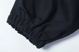 Detailansicht des elastischen Knöchelbündchens an der schwarzen Streetwear-Hose.