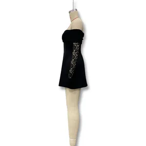 Side profile of elegant off-shoulder black mini dress with lace sleeves on mannequin