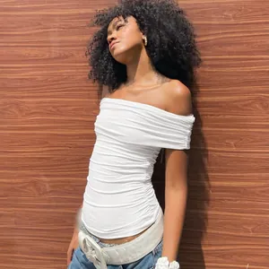 Detail showing the elegant folds and fit of the white off-the-shoulder ruched crop top