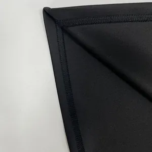 Close-up detail of high-quality stitching and black fabric texture on dress hem