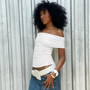 Detail view of a white off-the-shoulder ruched crop top with a fold-over neckline