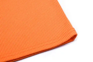 Detailed close-up of orange ribbed fabric hem with high-quality double stitching