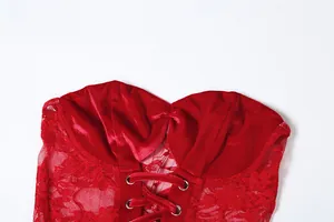 Detail view of the red velvet and lace tube dress featuring a lace-up front design.