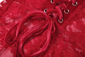 Macro detail view of red lace dress featuring velvet lace-up ribbon and silver metal eyelets.