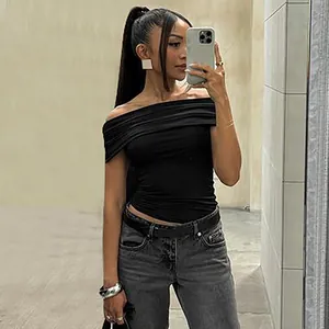 Stylish model wearing a black off-the-shoulder ruched cropped top for a slim fit look