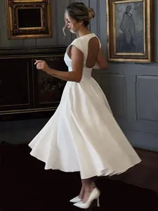 Elegant French style white backless midi dress with high waist and flared skirt