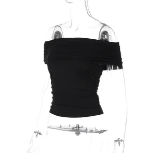 Close-up detail of the ruched fabric texture and off-shoulder fold on this black crop top