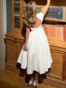 Elegant white French midi dress featuring a stylish open back design and flutter sleeves