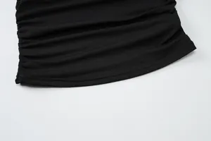 Close-up of ruched side detail on black slim fit crop top showing fabric texture