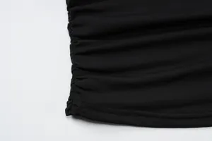 Close-up detail showing the black ruched fabric texture and precision stitching on the crop top hem
