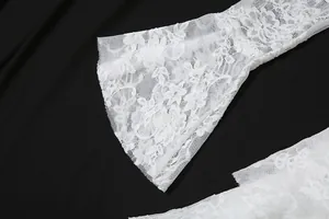 Detailansicht der eleganten weißen floralen Netzärmel aus Spitze an einem schwarzen Kleid
