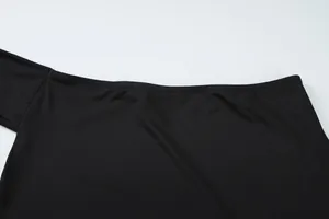 Λεπτομέρεια από τις λείες ραφές στη λαιμόκοψη του μαύρου crop top με έναν ώμο.