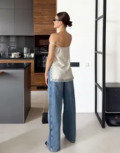 Vue arrière détaillée d'un caraco en satin chic avec des bordures en dentelle blanche