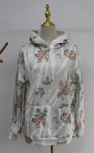Detail of white oversized hoodie featuring autumn maple leaf print and front pocket.