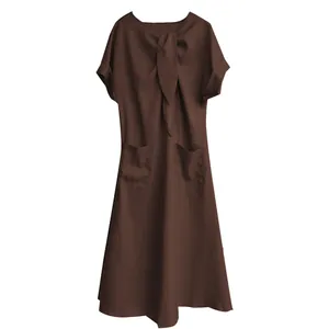 Détail d'une robe longue marron à manches courtes avec nœud papillon et deux poches.