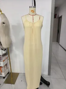 Detailansicht eines cremefarbenen Plissee-Maxikleids mit schmalen Trägern am Mannequin