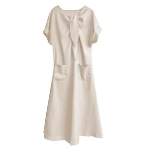 Vue détaillée du nœud au col et des poches sur cette élégante robe longue beige.