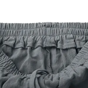 Dettaglio della vita alta elastica con coulisse su pantaloncini grigi in misto lino