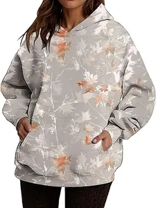 Detail view of oversized hoodie with autumn maple leaf print and front pocket.