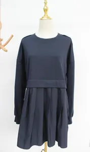Detail view of a navy blue long-sleeved pleated sweatshirt dress on a mannequin
