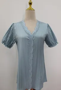 Detail of light blue short sleeve blouse with V-neck lace trim and pleated texture.